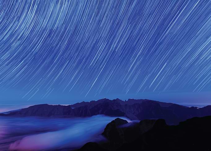 Star Trails Over Mountains and Clouds