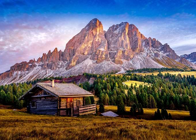 Rustic cabin in the mountains at sunset