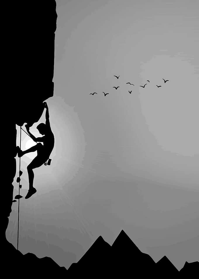 Silhouette of a rock climber against a gradient sky