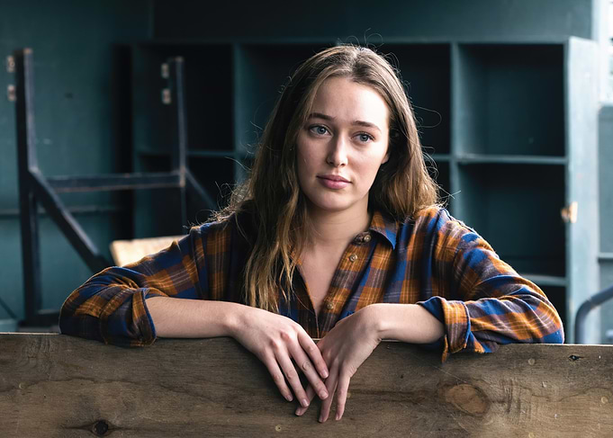 alycia debnam carey in plaid shirt leaning on wood