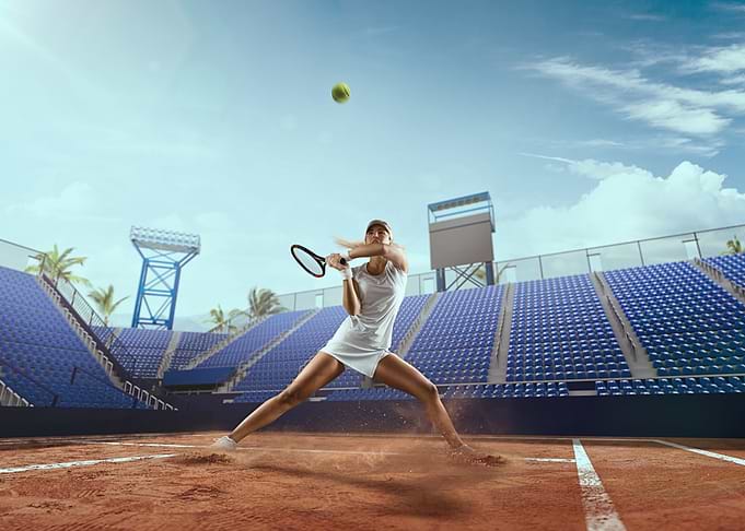 Tennis player hitting a ball on clay court