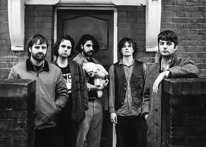 Band Poses Outside Brick Building fontaines dc