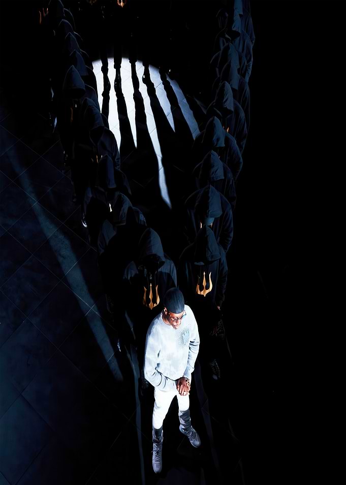 Man in White Leading Hooded Figures