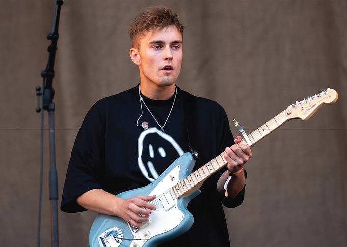 Musician playing a light blue electric guitar