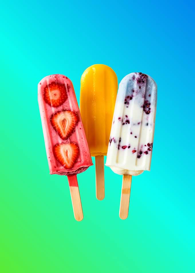 Three colorful popsicles on a gradient background