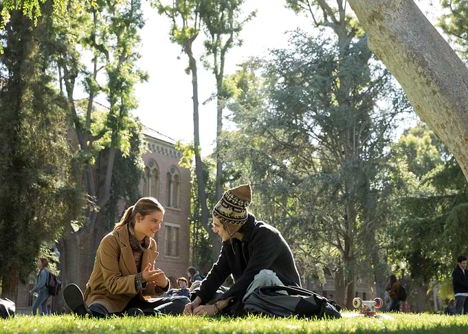 Couple sitting on grass on campus