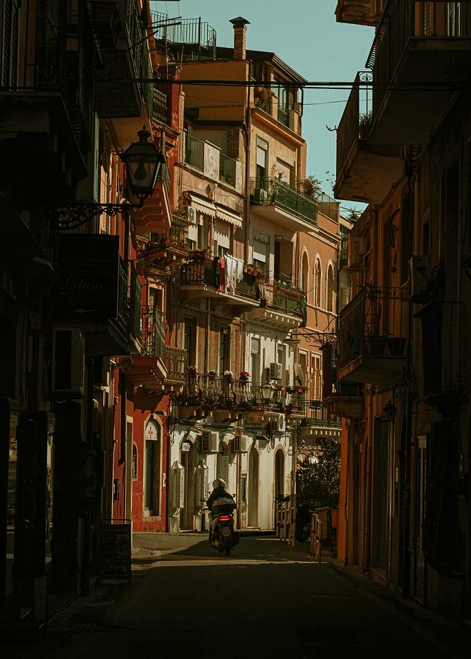 Motorcyclist in Narrow traditional Italian street