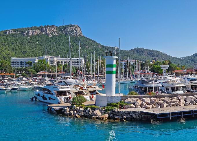 Marina with Lighthouse and Mountain Backdrop