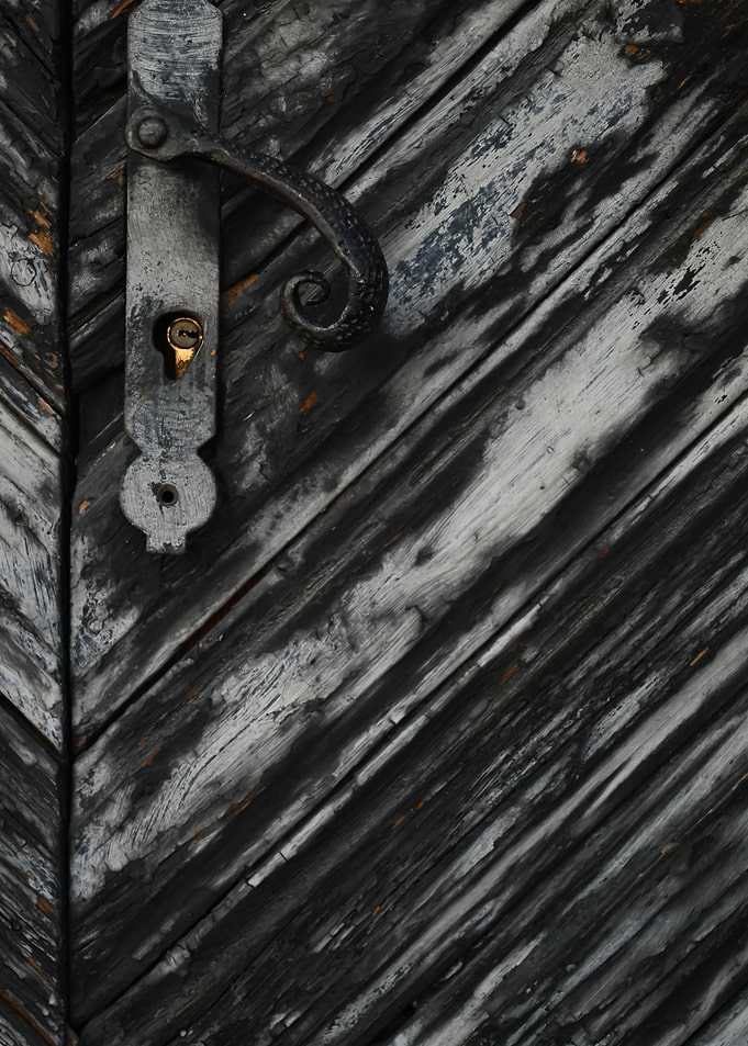 Old wooden door with ornate handle and lock