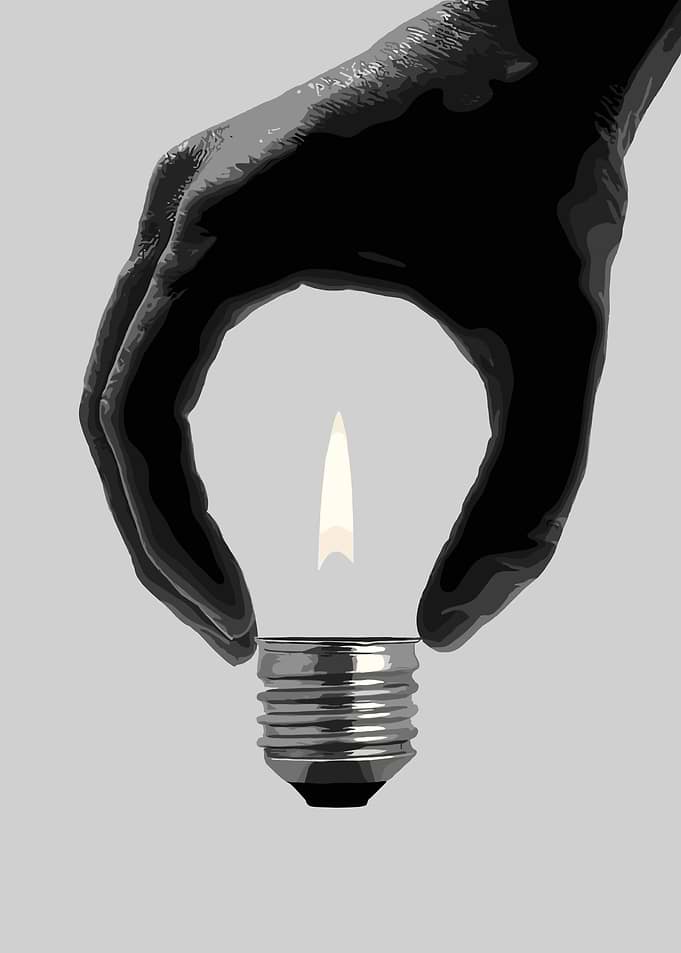 Hand holding a lightbulb with a flame