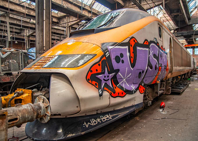 Graffiti-covered train in industrial setting