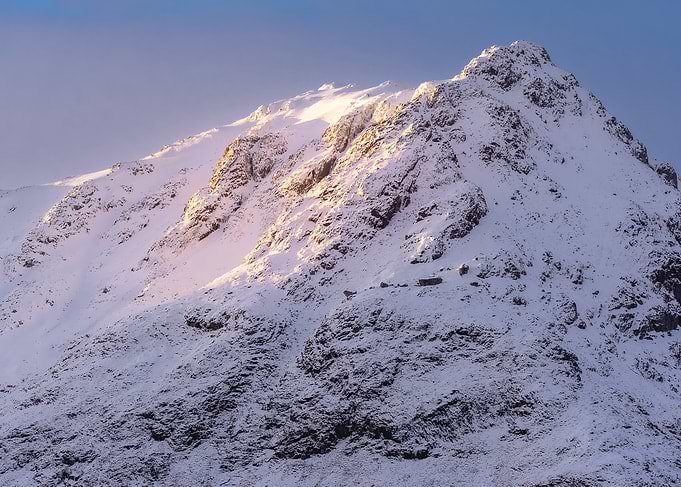 Snow-covered mountain peak at sunrise Glencoe