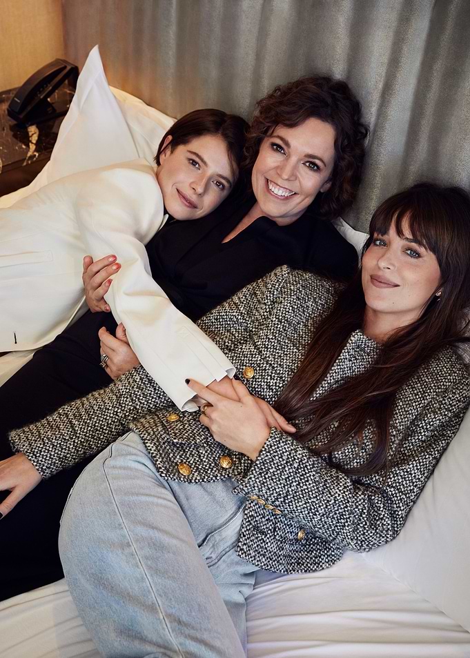 Three women posing on a bed