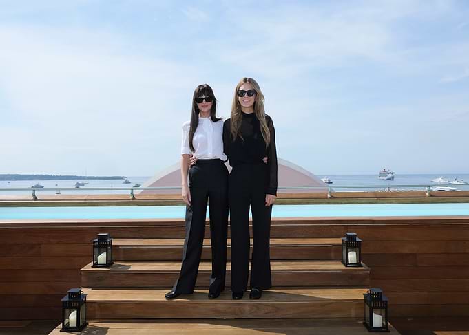 Two women posing by a pool