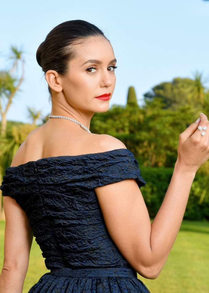 Nina Dobrev in a dark blue off-the-shoulder dress