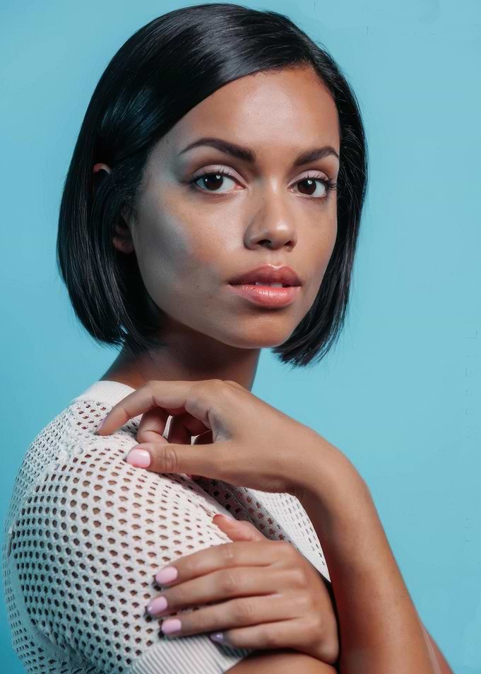 Georgina Campbell with short dark hair and mesh top