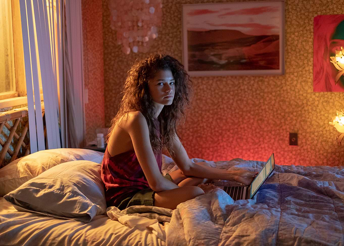Zendaya on a bed with a laptop