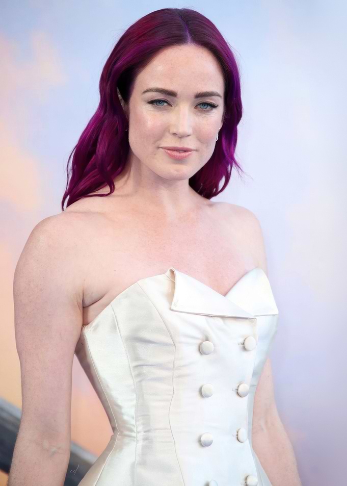 Caity Lotz with purple hair in a white dress