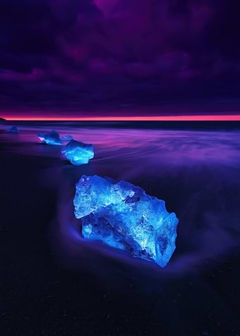 Glowing Ice Chunks on a Beach at Dusk