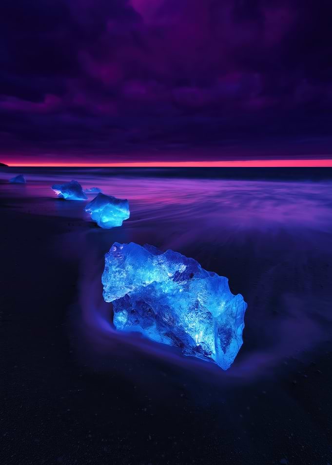 Glowing Ice Chunks on a Beach at Dusk