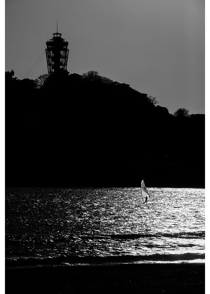 Windsurfer silhouetted against sunlit sea