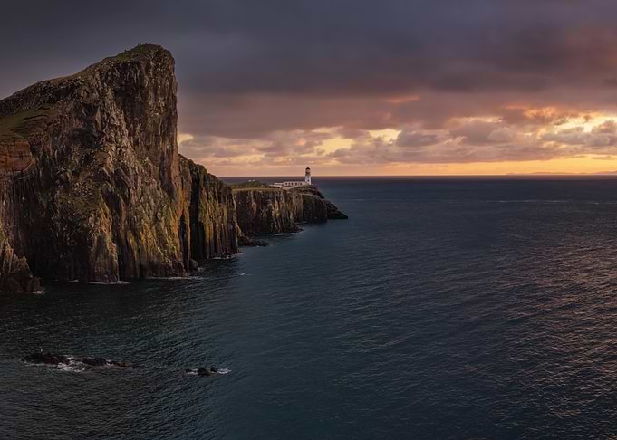 Lighthouse on a cliff at sunset