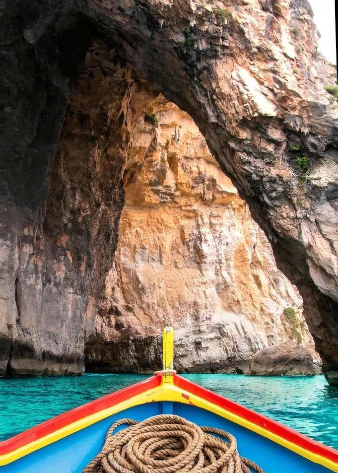 Boat entering the sea cave Blue Grotto in Malta