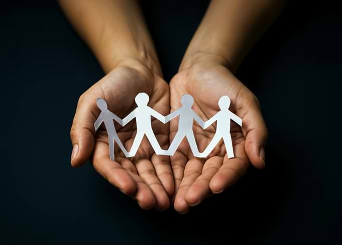 Hands holding paper people chain