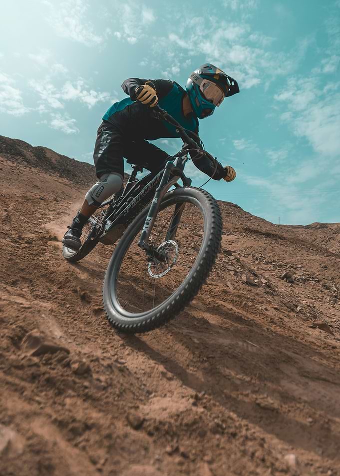 Mountain biker descending a dusty slope