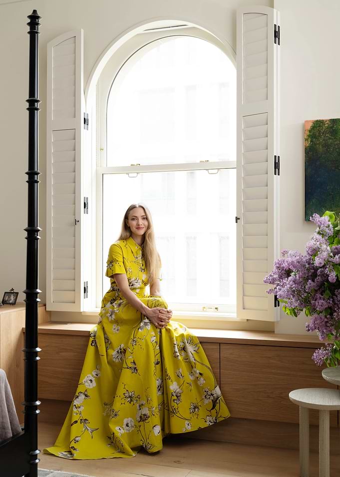 Woman in yellow floral dress by window