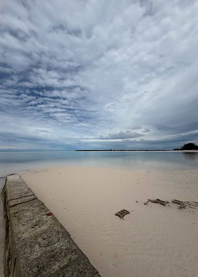 Beach with Calm Water and Cloudy Sky