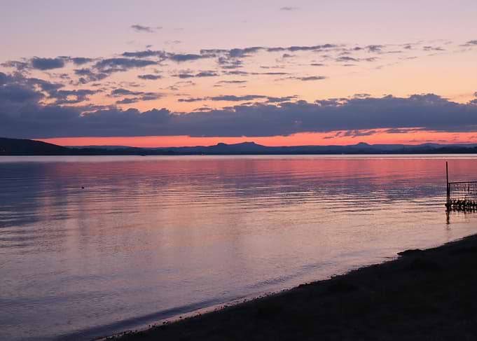 Sunset over a calm lake with mountains