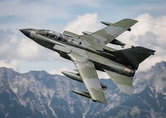 Military Jet Flying Over Mountains