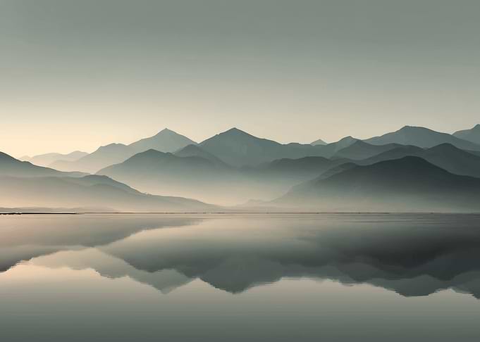 Misty Mountains Reflected in Calm Water