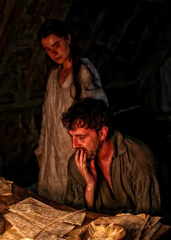 Couple reading old documents by candlelight
