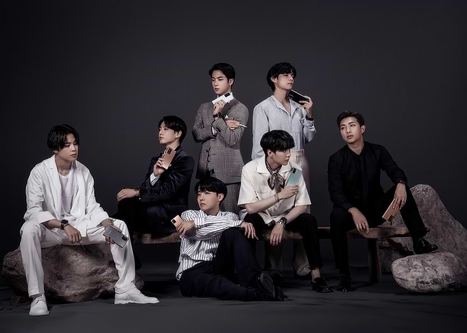 BTS members posing with phones