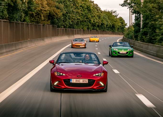 4 generations of Mazda MX-5 Driving on Highway