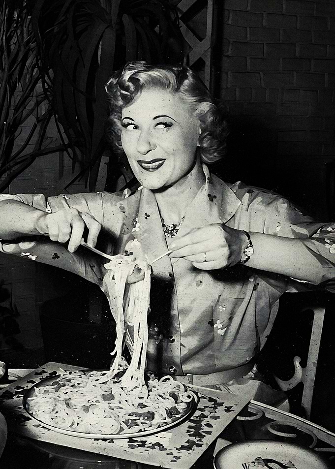 Woman eating spaghetti with chopsticks
