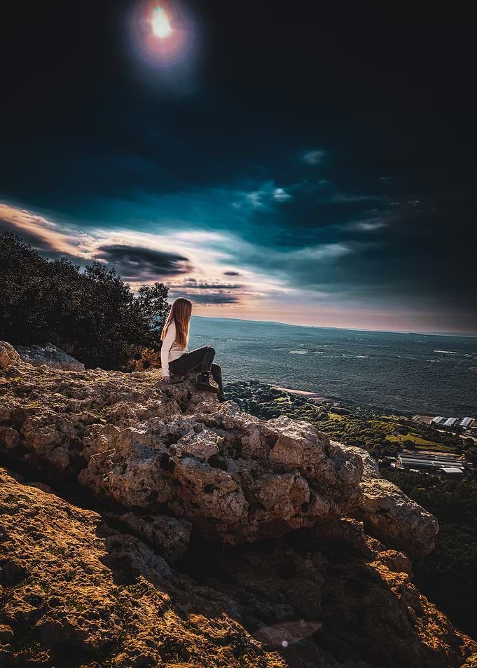 Woman on rocky outcrop overlooking landscape