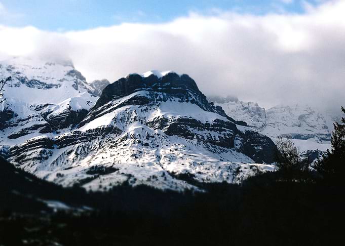 Snow-covered mountain peak under clouds