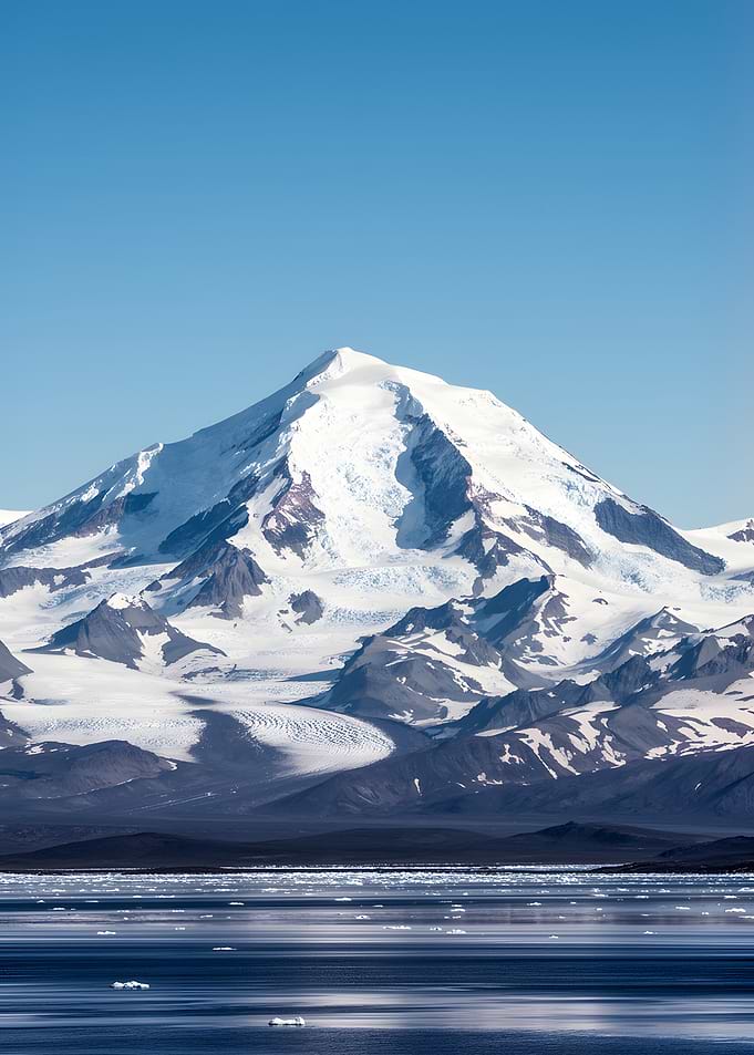 Snow-capped mountain over icy ocean