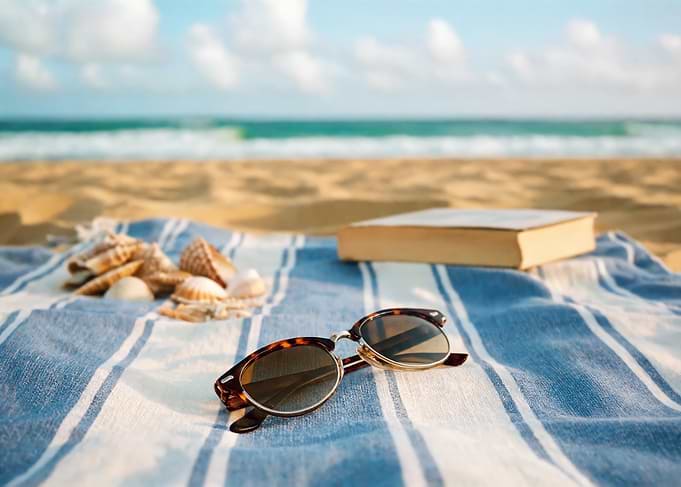Beach scene with book and sunglasses