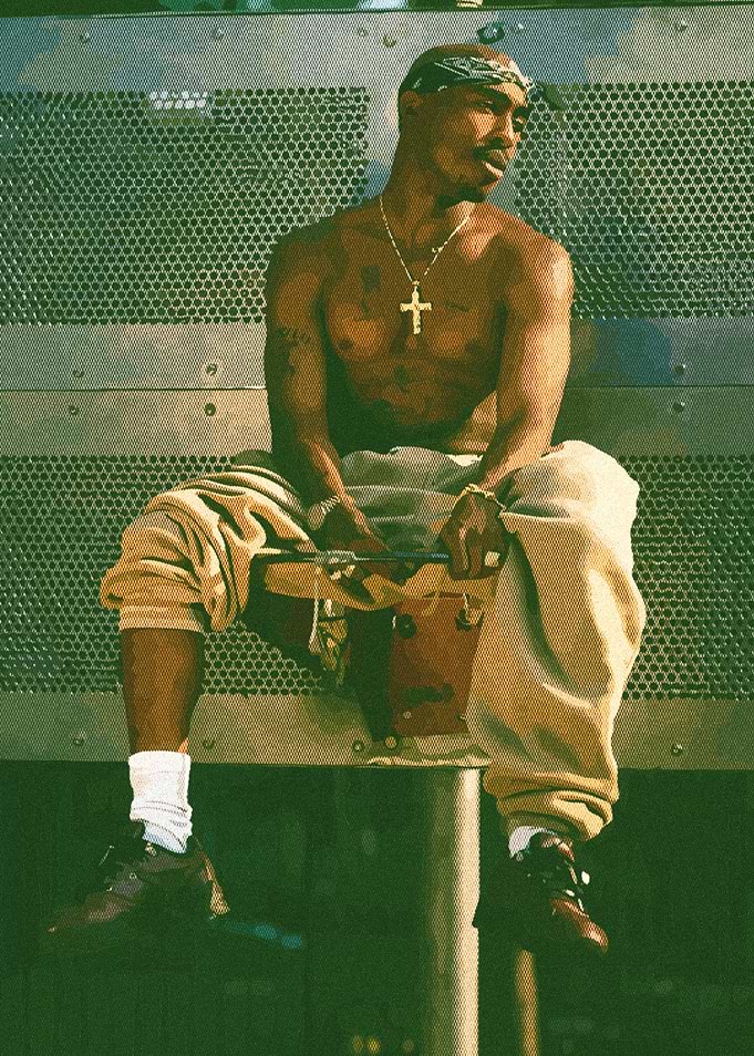 Tupac Shakur sitting outdoors