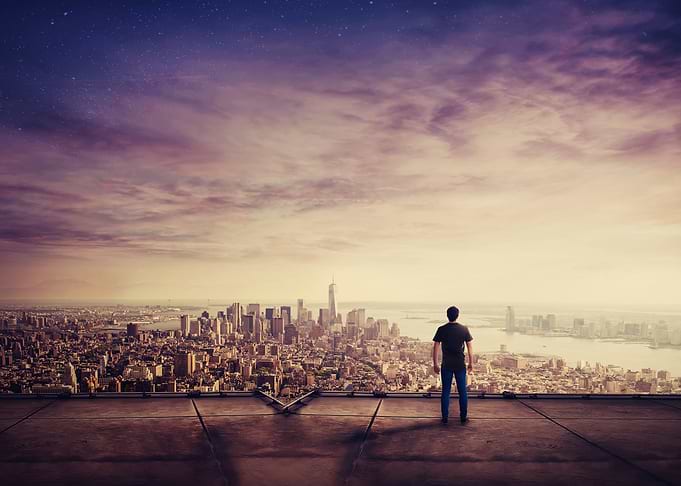 Man overlooking a city at dusk