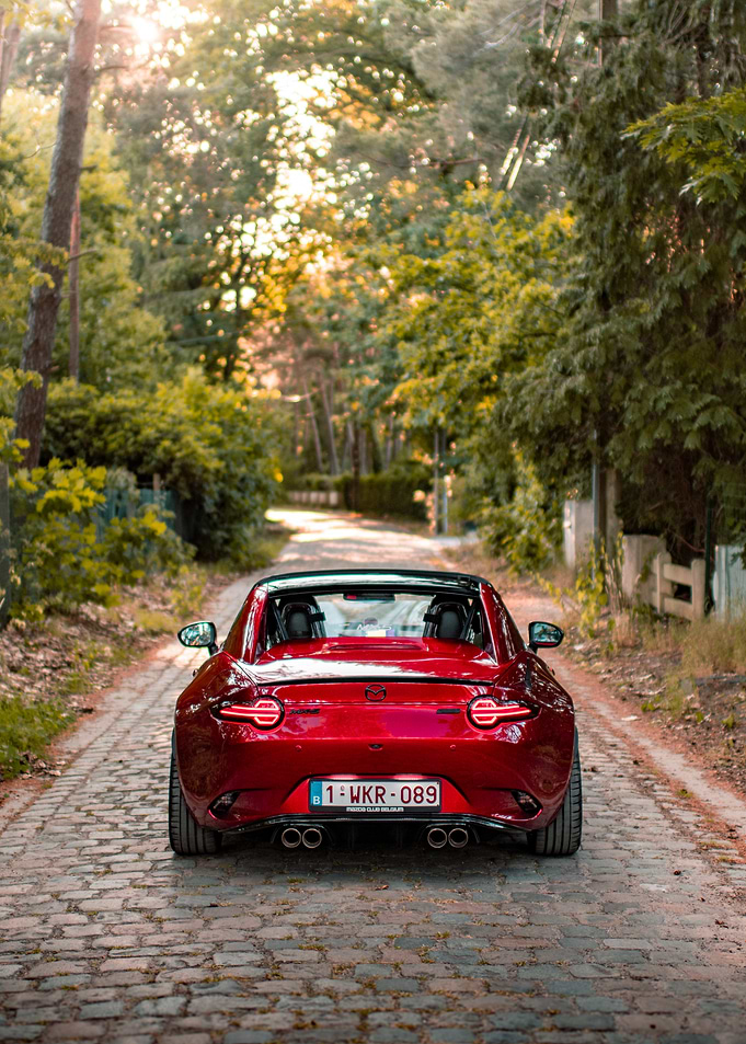 Red Mazda MX-5 on Cobblestone Road