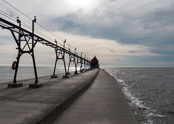 Pier leading to a red lighthouse