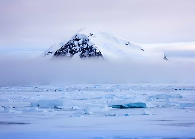Misty Antarctic Mountain Over Ice Floes