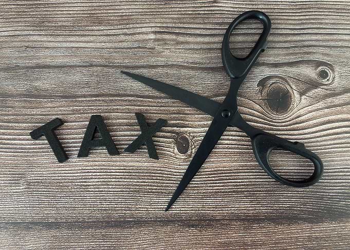 Scissors cutting the word TAX