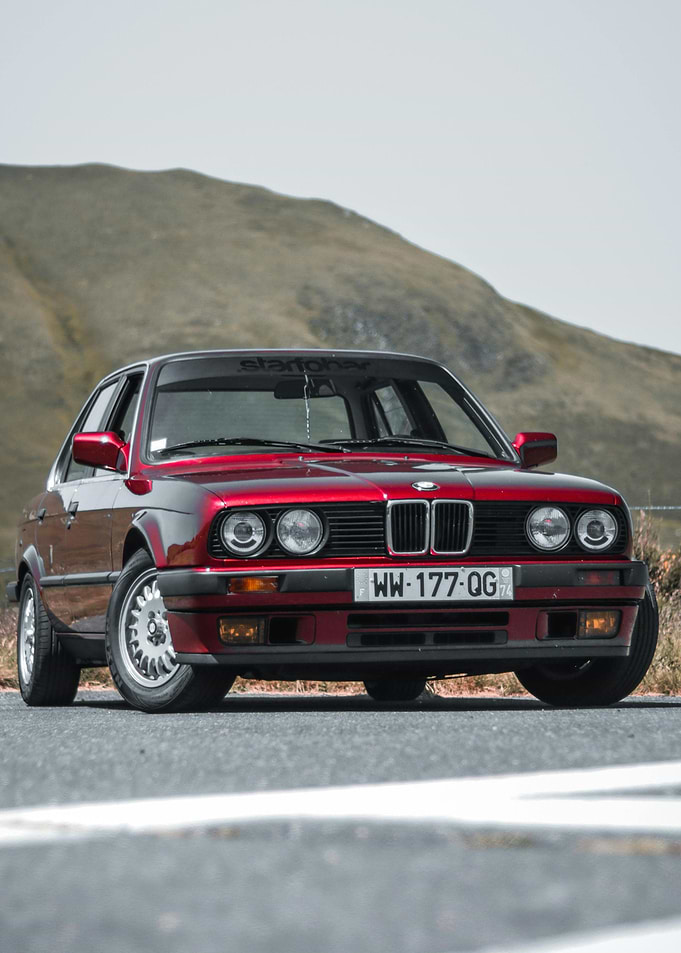 Red BMW E30 on a Mountain Road