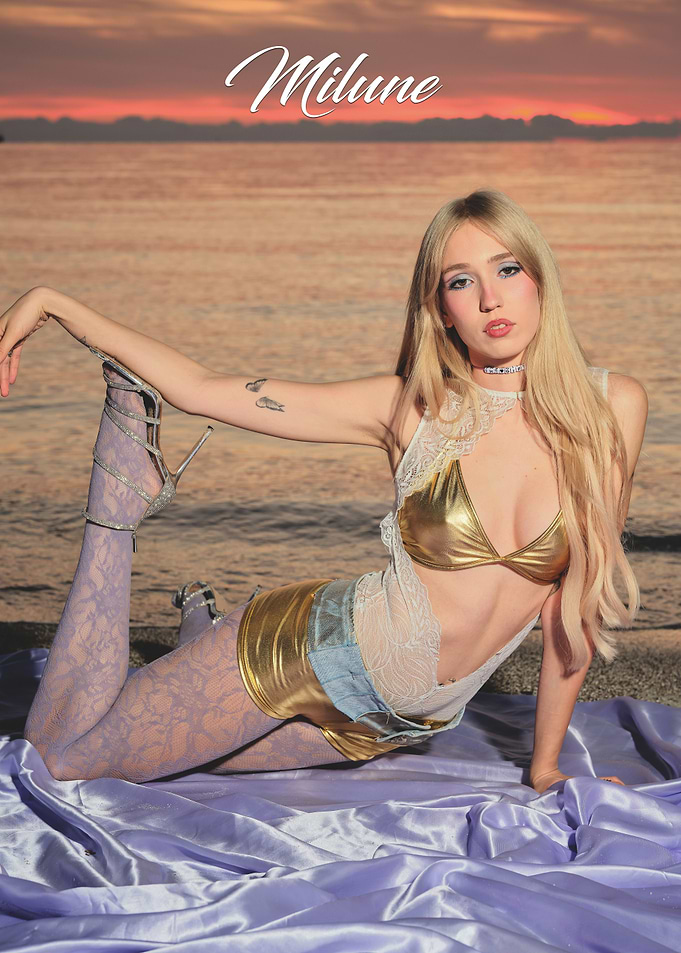 Milune posing on a beach at sunset